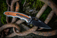 Stainless Steel Folding Knife resting open on rusted link chain, lifestyle photo