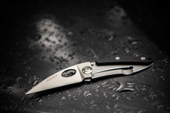 Stainless Steel Blade Folding Knife Laying Open on Dark Wet Surface, lifestyle photo